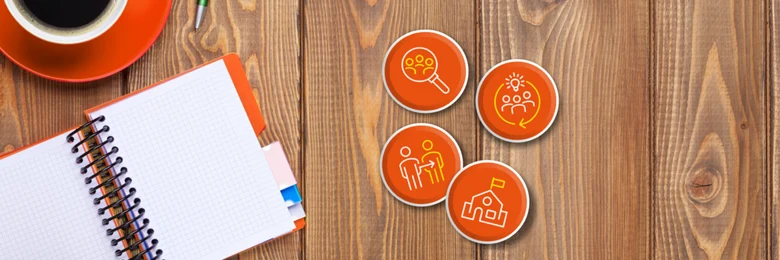 Auf einem Tisch liegen ein Handy, ein Notizbuch, eine Tasse Kaffee und vier orangene Kreise mit Icons.