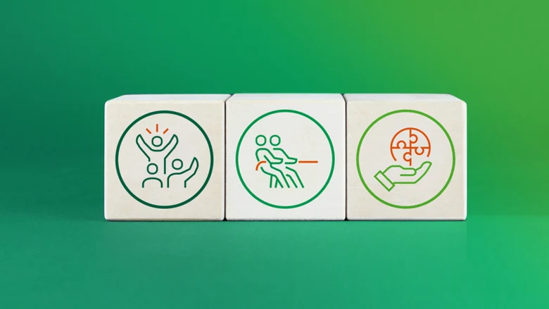 Vor einem grünen Hintergrund sind drei Holzklötze mit verschiedenen Icons abgebildet.
