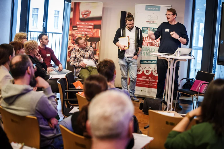 zwei junge Männer tragen in einem Workshop ein Thema vor.