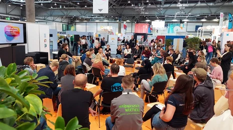 Blick aus der Vogelperspektive auf eine FishBowl-Diskussion, an der einige Personen teilnehmen.