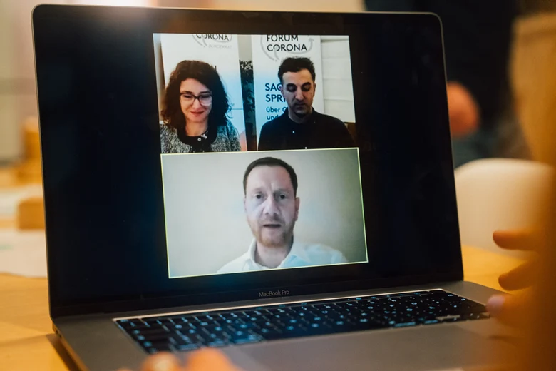Auf einem Laptop sind die Videos des Moderationsteams und von Ministerpräsident Kretschmer zu sehen.