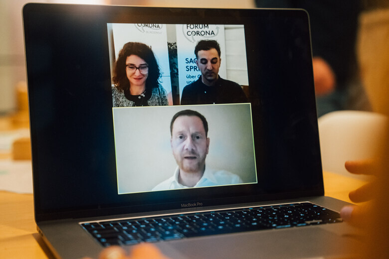 Auf einem Laptop sind die Videos des Moderationsteams und von Ministerpräsident Kretschmer zu sehen.