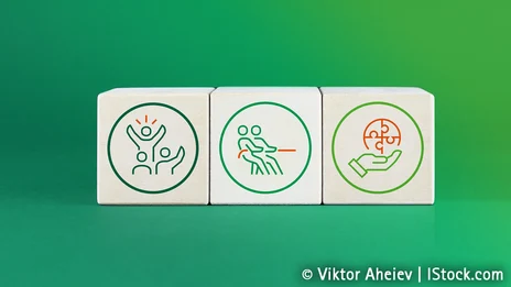 Vor einem grünen Hintergrund sind drei Holzklötze abgebildet, auf denen drei verschiedene Icons zu sehen sind.