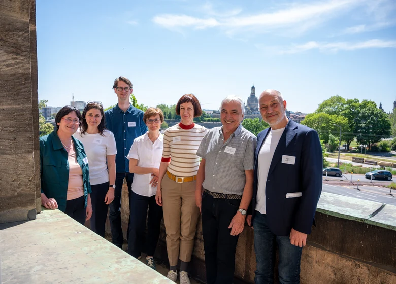 Die Mitglieder des Fachbeirats posieren vor der Kulisse der Dresdner Altstadt für ein Gruppenfoto.