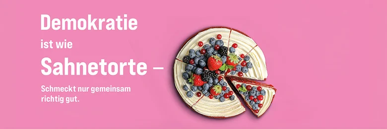 Vor einem rosa Hintergrund ist mittig eine Sahnetorte mit Beeren zu sehen, daneben steht: Demokratie ist wie Sahnetorte - Schmeckt nur gemeinsam richtig gut.