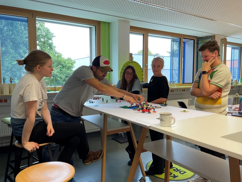 Teilnehmende bauen an Legomodell